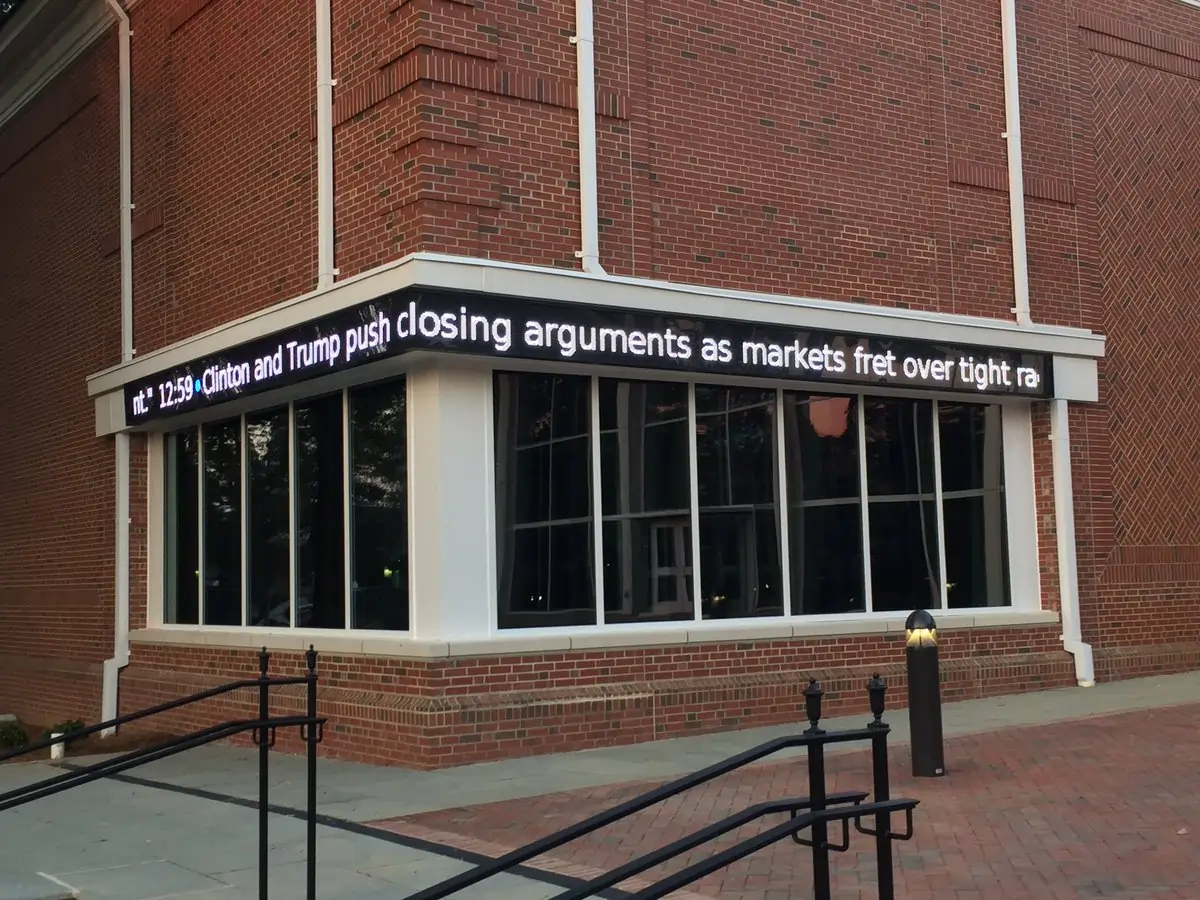 An outdoor LED ticker mounted on the exterior entrance corner of Elon University. By Rise Display.