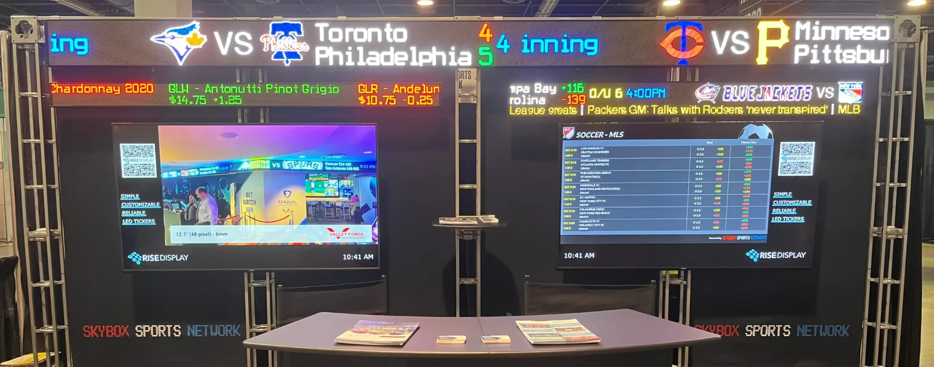 Rise Display trade show booth featuring sports tickers and stock ticker options.
